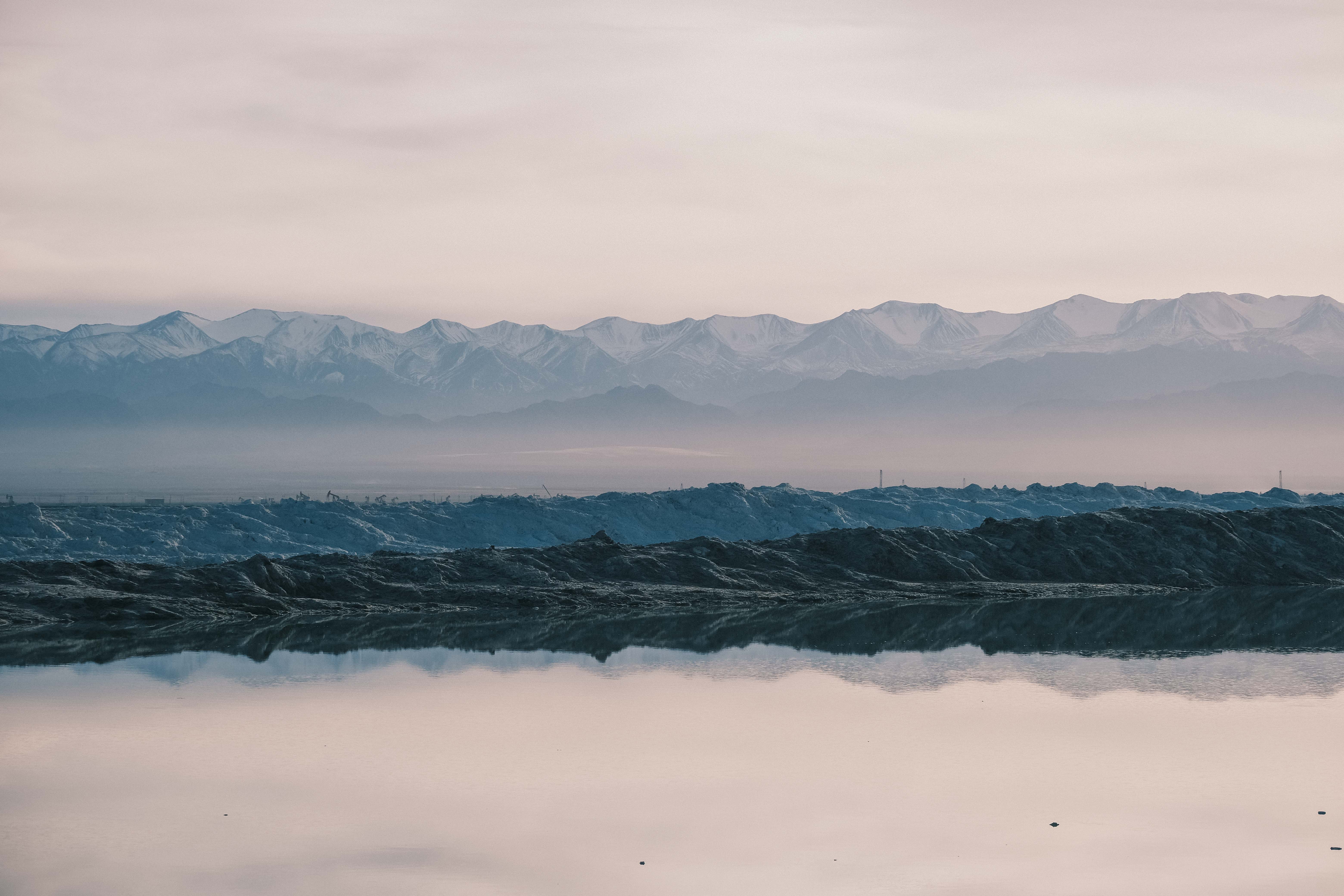 Pale mountains above dark salt deposits and still water