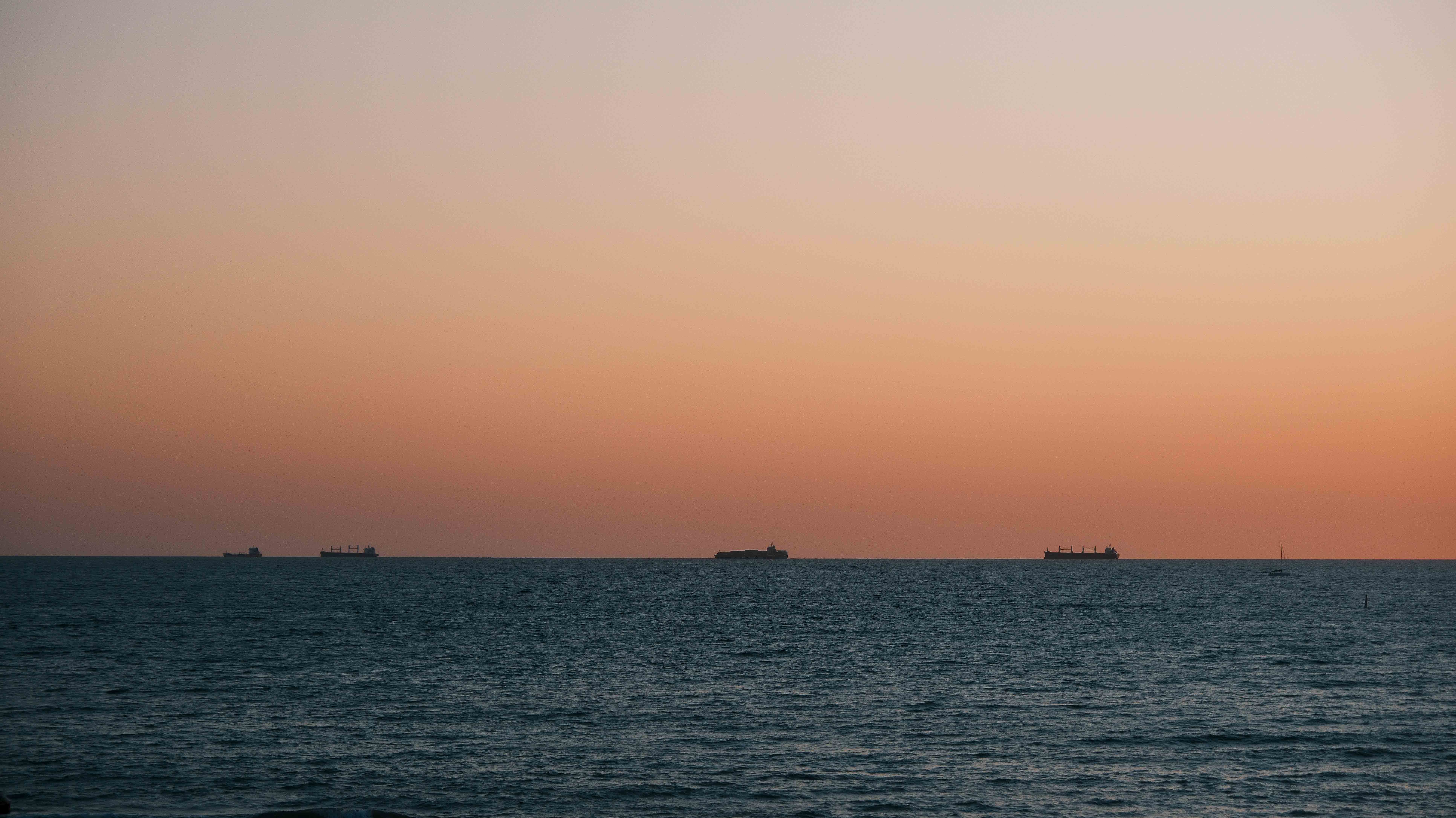 Ships silhouetted along the evening horizon
